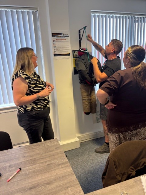 Trainer guiding care staff through practical moving and handling training